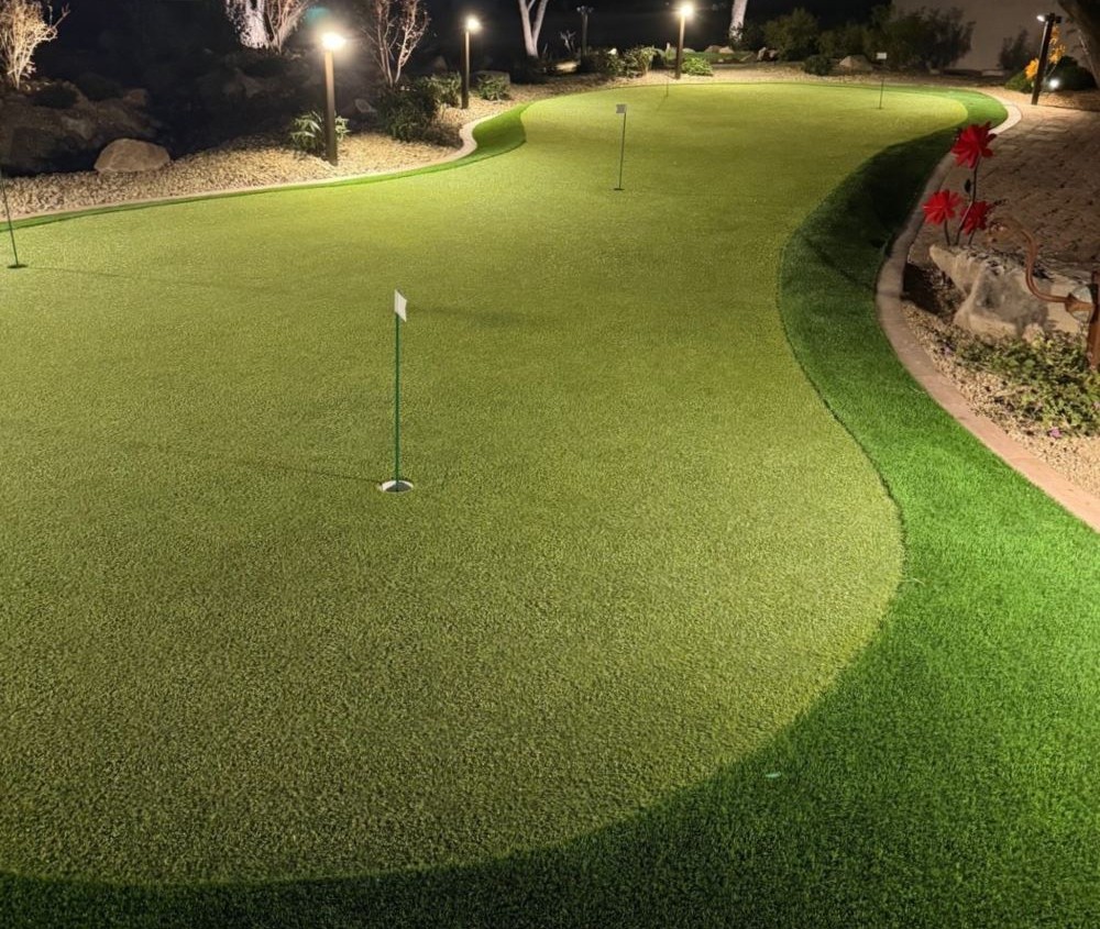 putting green with lights around it at night