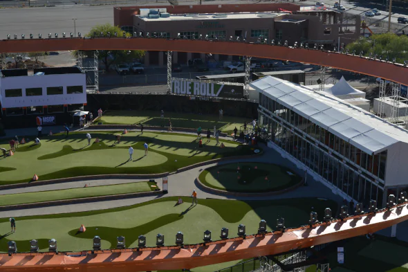 Large-scale artificial turf installation at an urban entertainment venue, featuring custom putting greens, synthetic grass fairways, and modern rooftop golf experience.