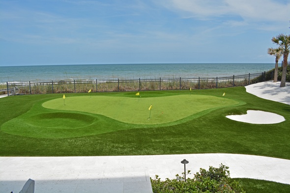 Las Vegas Synthetic grass golf green by the sea with yellow flags and a sand bunker